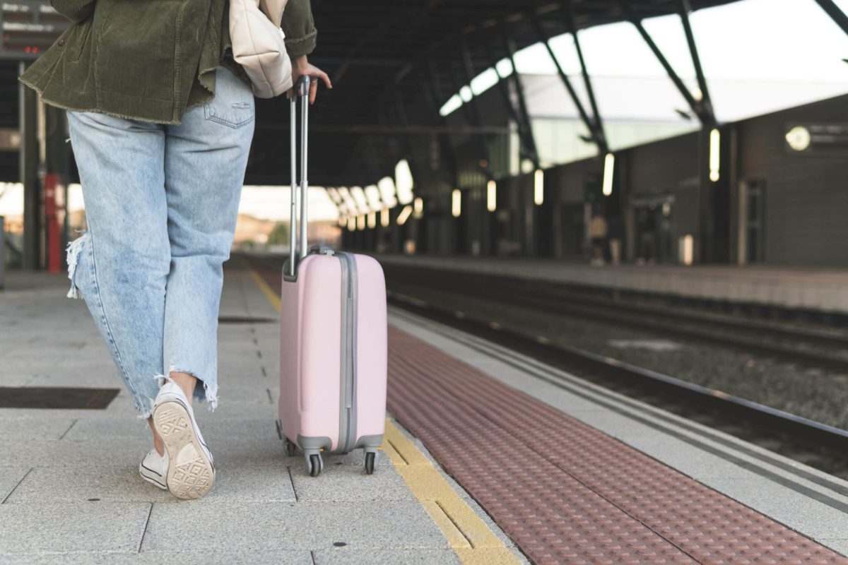 Frau mit Koffer am Bahnsteig