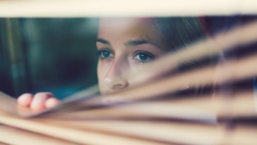 frau traurig aus dem Fenster schauen