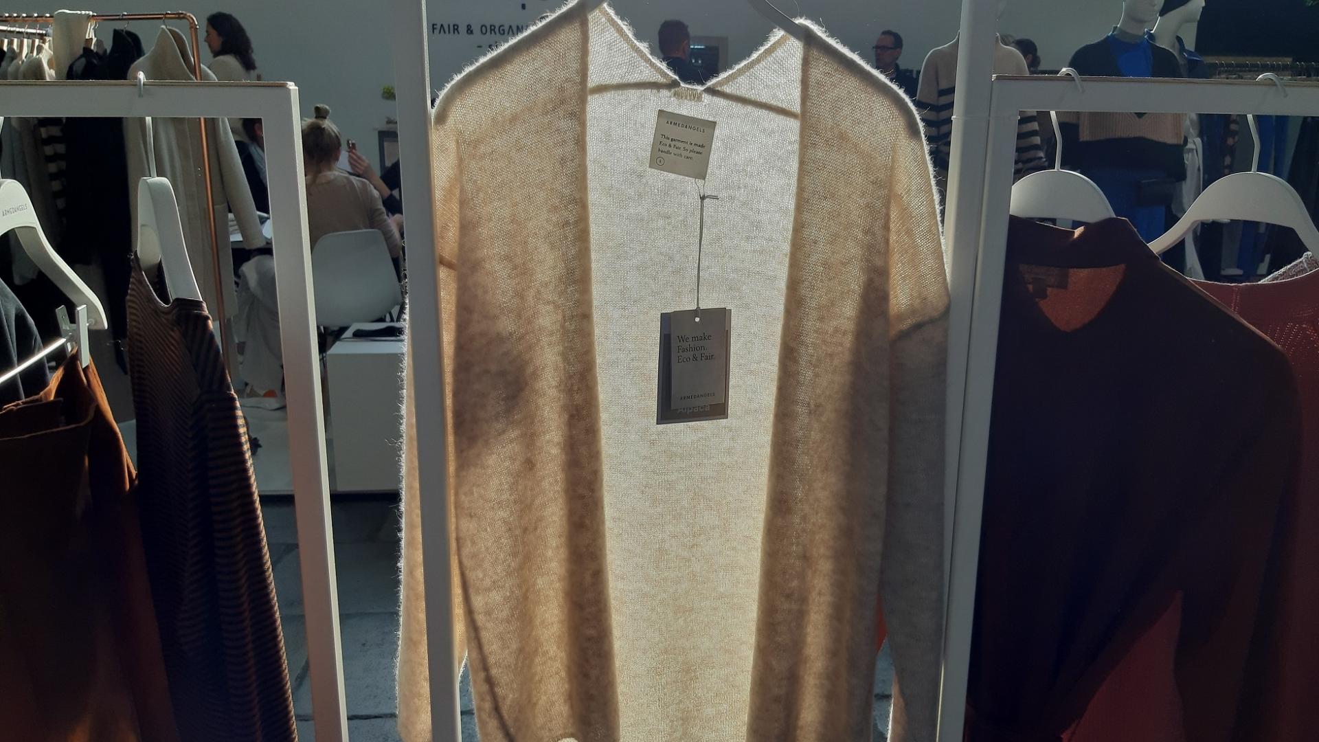 beige Strickjacke auf einem Garderobenständer von der Sonne angeleuchtet