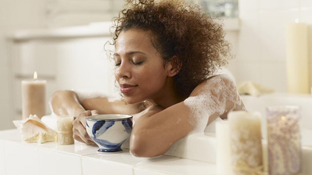 frau afro locken kaffee badewanne kerzen Ernährung während der Periode
