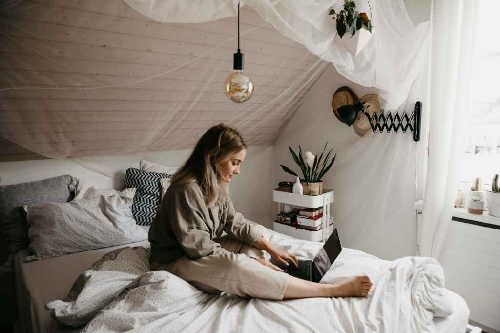 Frau mit laptop auf dem Bett