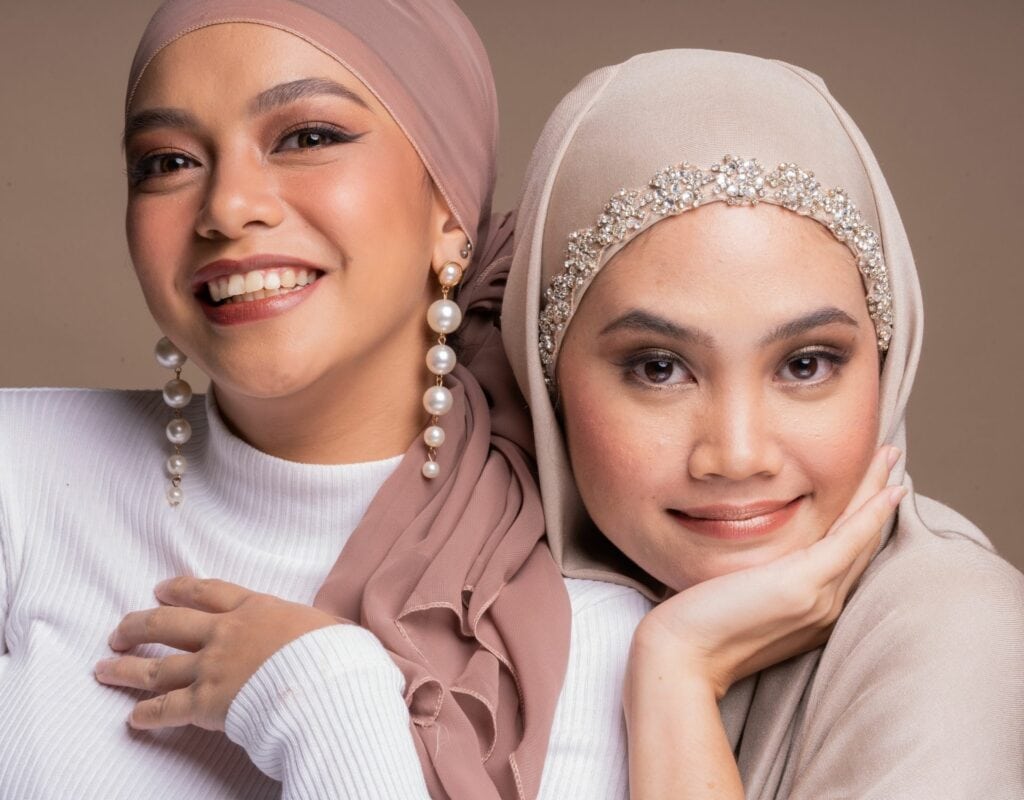 zwei junge frauen mit hijab und ohrringen