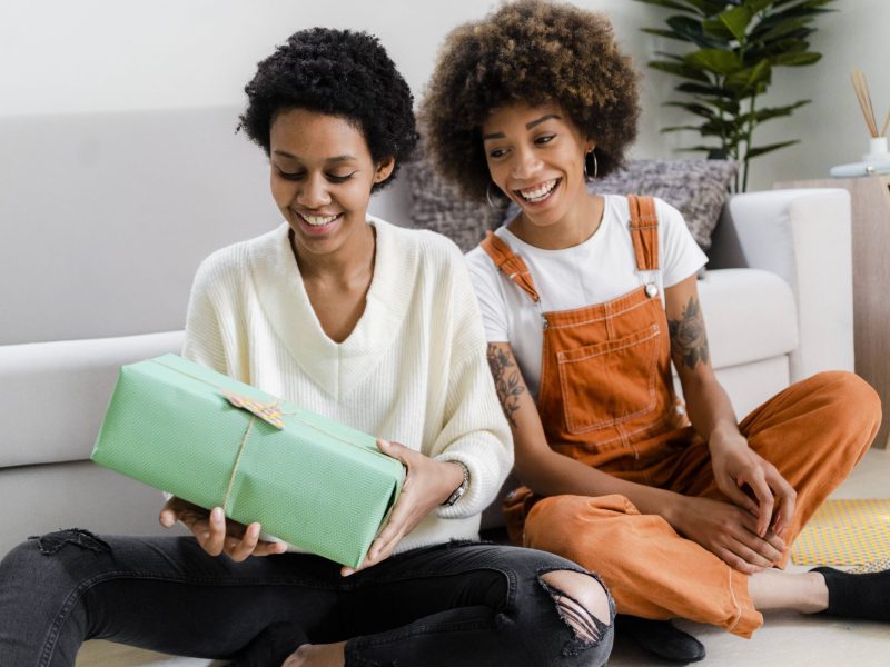 Frauen überreichen sich Geschenke