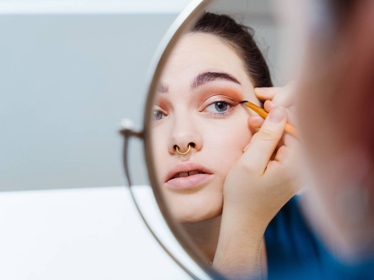 Frau zieht sich Eyeliner