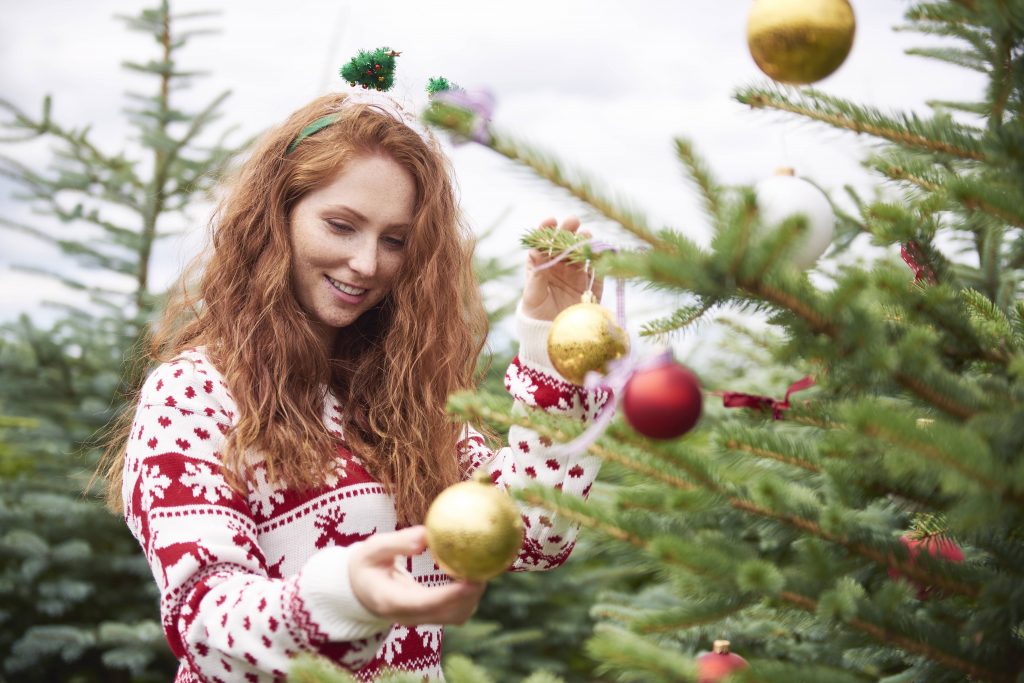 Frau am Weihnachtsbaum mit weihnachtlichem Haarschmuck