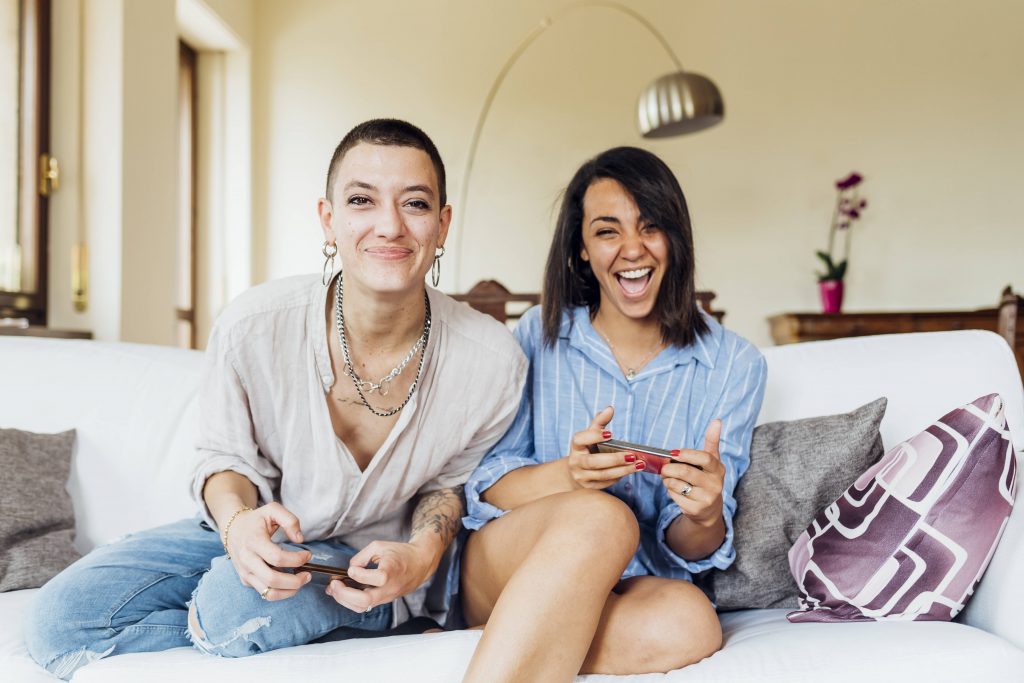 Zwei Frauen spielen ein Spiel auf dem Sofa