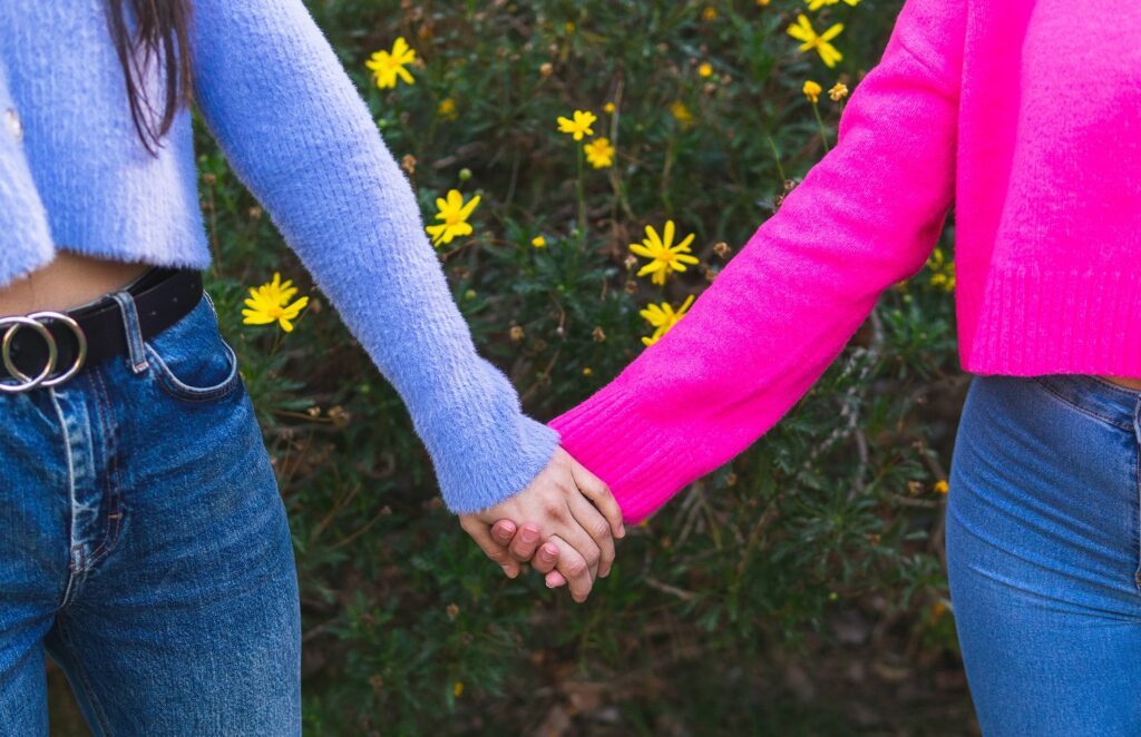 Zwei Frauen halten sich an den Händen