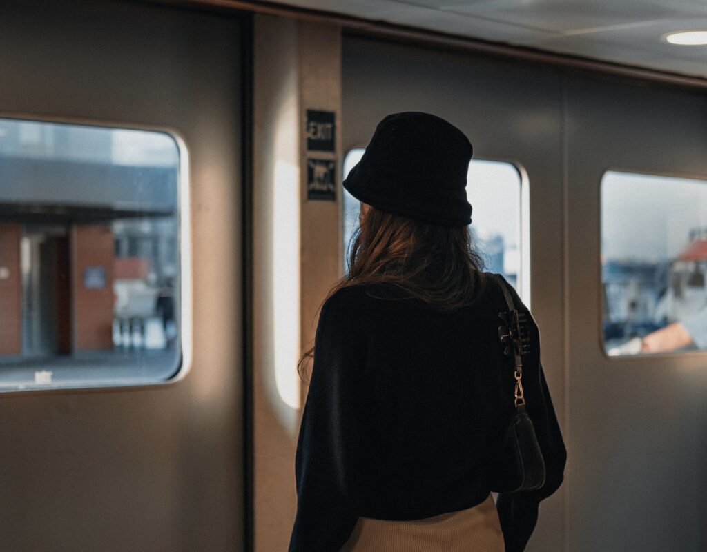 Frau steht an Bahnstation