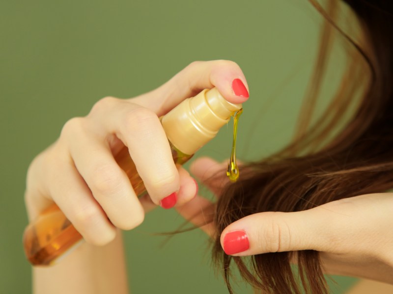 frau macht sich öl in die haare