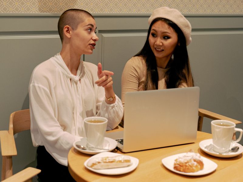 Zwei Frauen am Laptop mit Kaffee