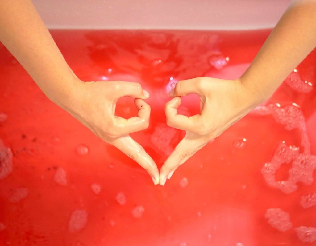 Hände über Badewanne mit roter Flüssigkeit