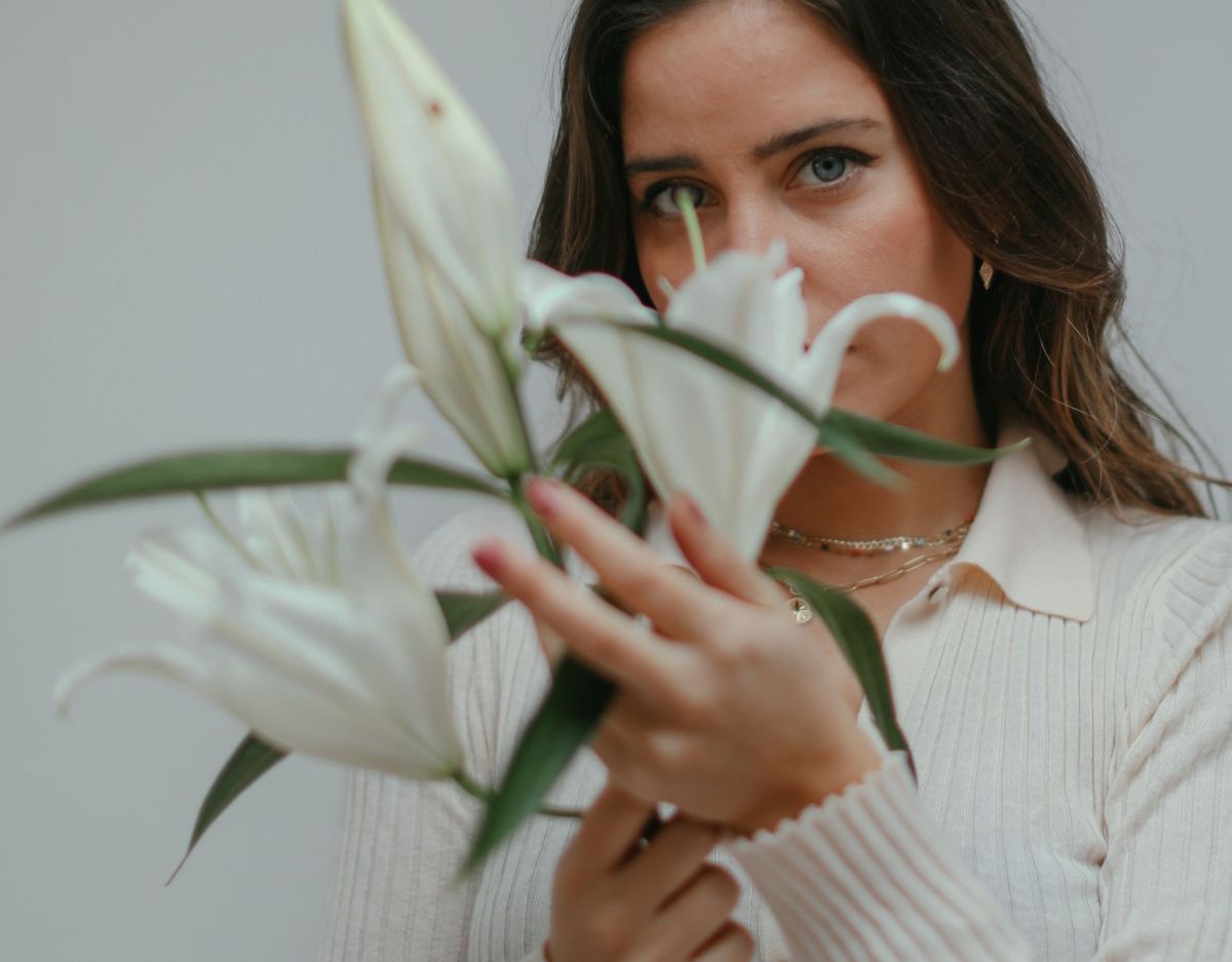 Frau mit Blumen vorm Gesicht