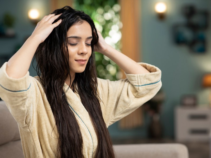 Frau massiert sich Haare