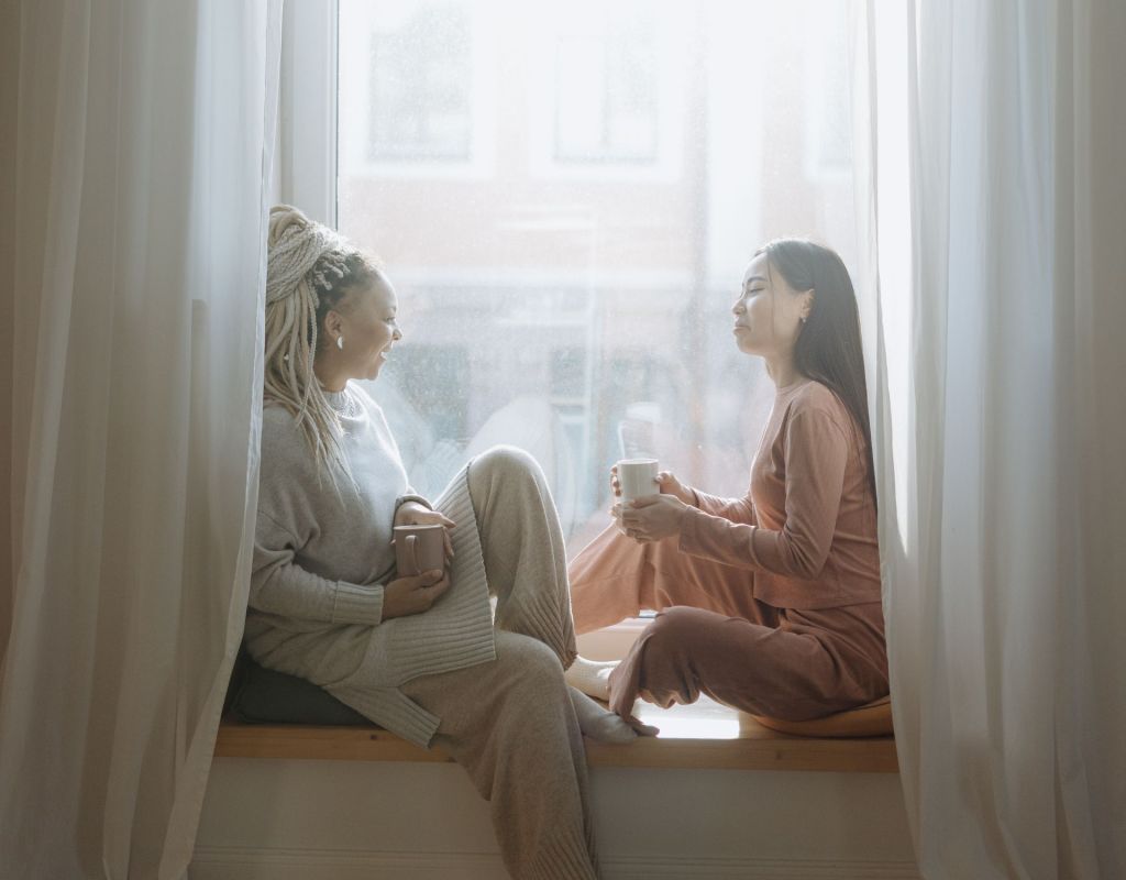 Zwei Frauen auf Fensterbank