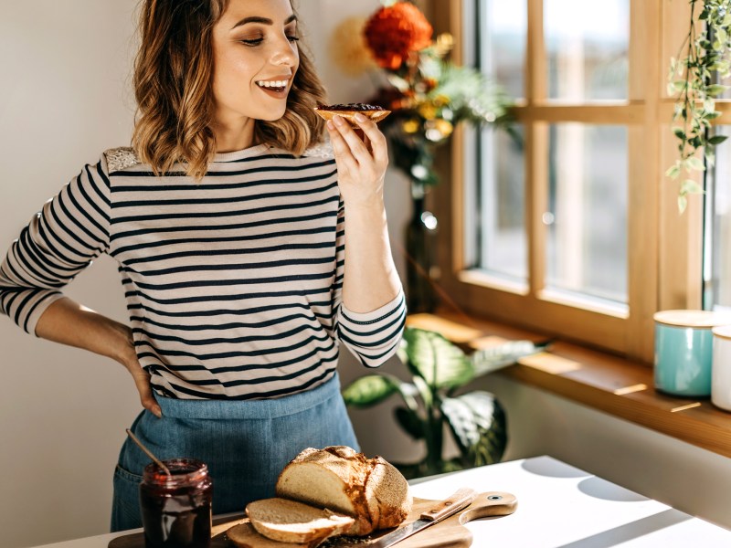 Frau beißt in Marmeladenbrötchen