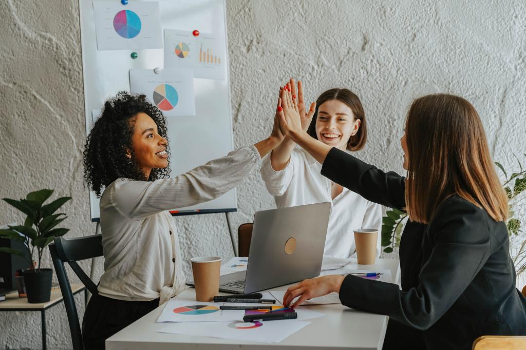 Frauen im Büro geben sich einen Handschlag