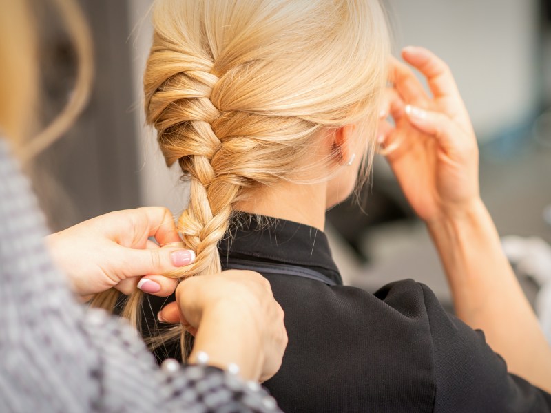 Frau flechtet Haare