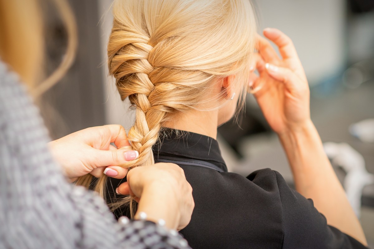 Frau flechtet Haare