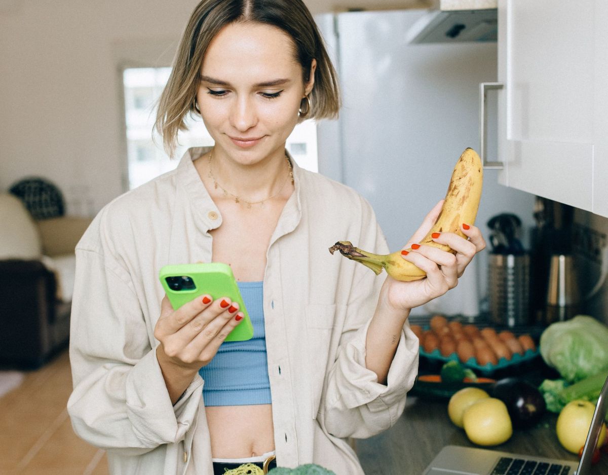 Frau mit Handy und Einkäufen