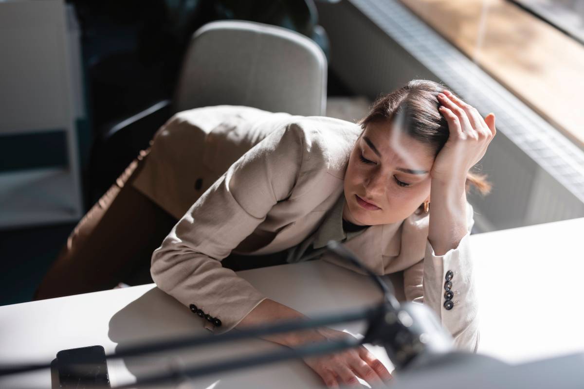 Frau sitzt traurig am Büro-Tisch