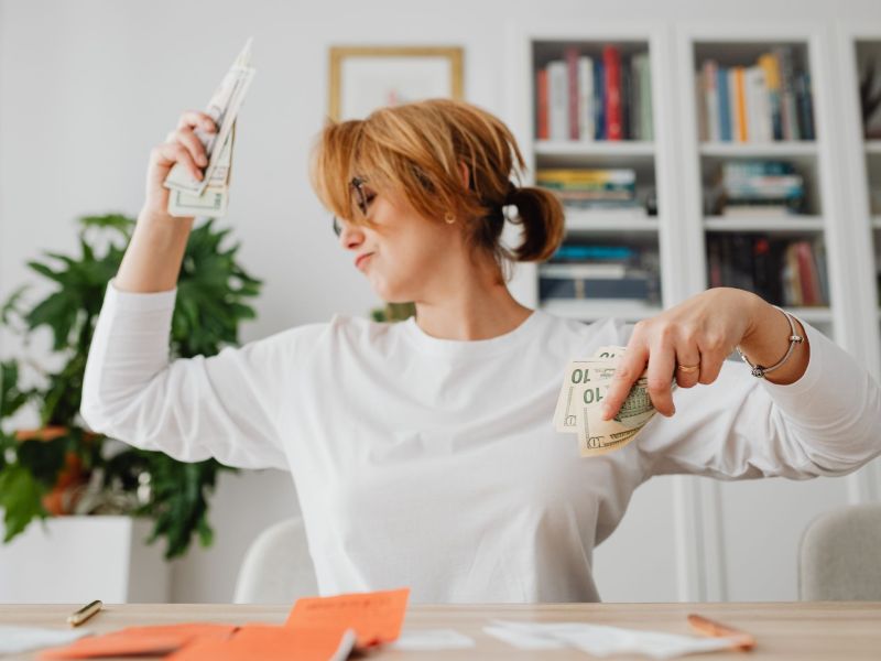 Frau tanzt mit Geld