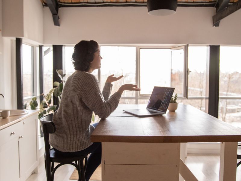 Frau am Tisch im virtuellen Meeting