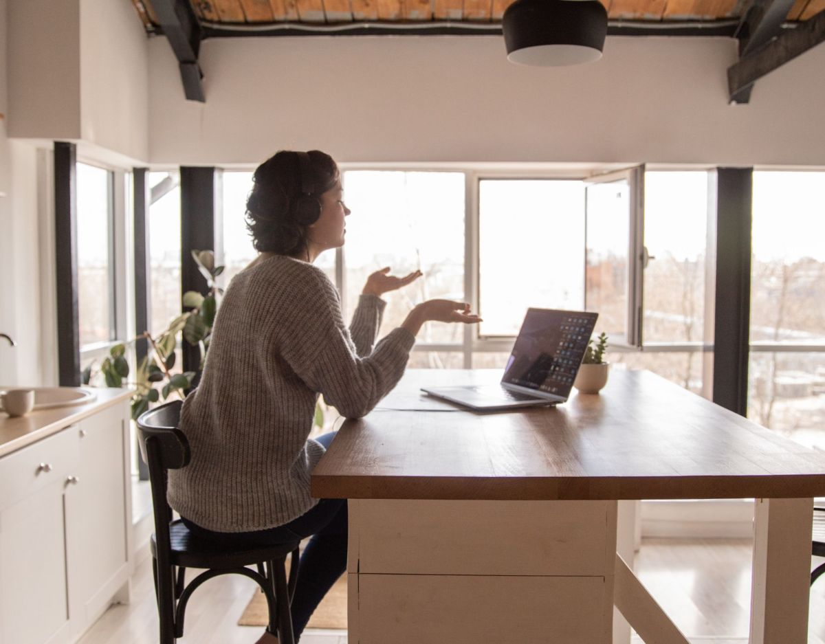 Frau am Tisch im virtuellen Meeting