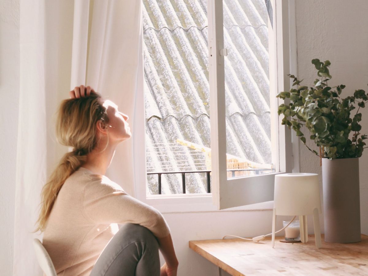 Frau am geÃ¶ffneten Fenster