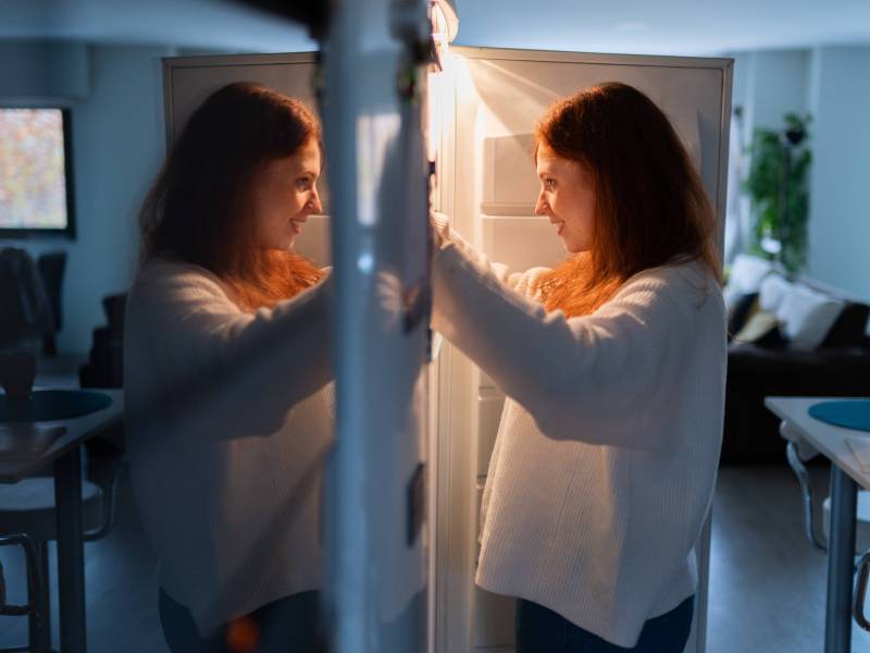 Frau sucht im Kühlschrank