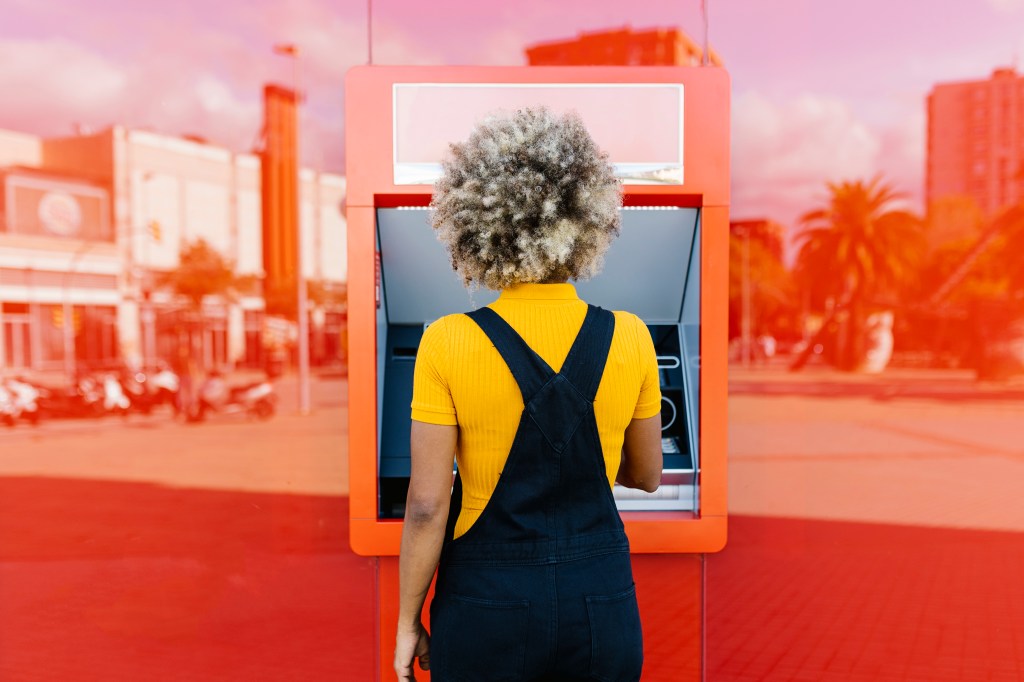 Frau will an Geldautomat Geld abheben