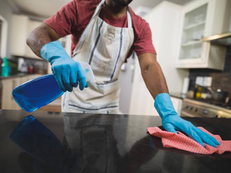 mann putzen flasche glasreiniger hausarbeit