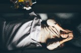 Frau liegt auf dem Sofa und hält sich die Augen zu