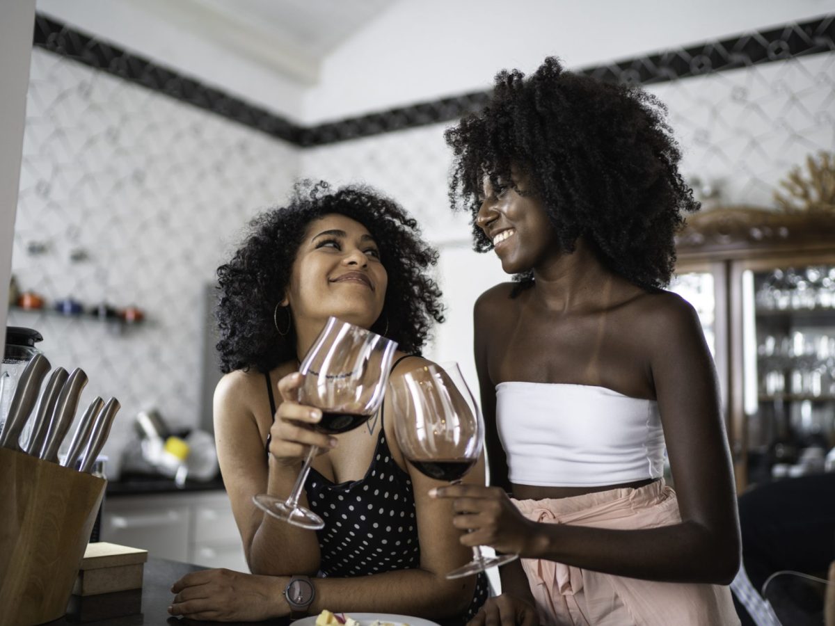 Zwei Frauen stoÃŸen mit Rotwein an