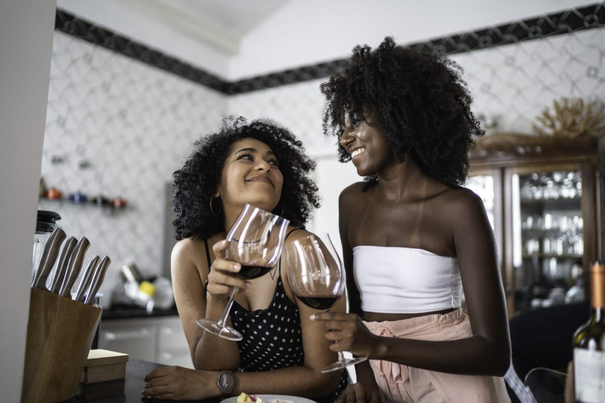 Zwei Frauen stoßen mit Rotwein an