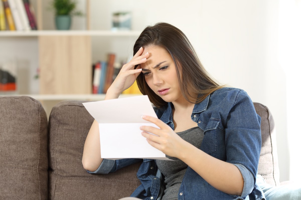 Frau hält Brief in der Hand und schaut verärgert.