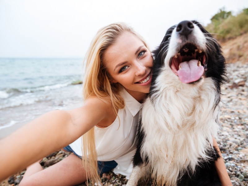 Frau macht Selfie mit einem Hund.