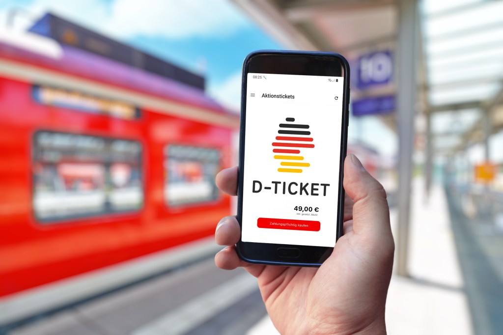 Person hat das Deutschlandticket auf seinem Handy.