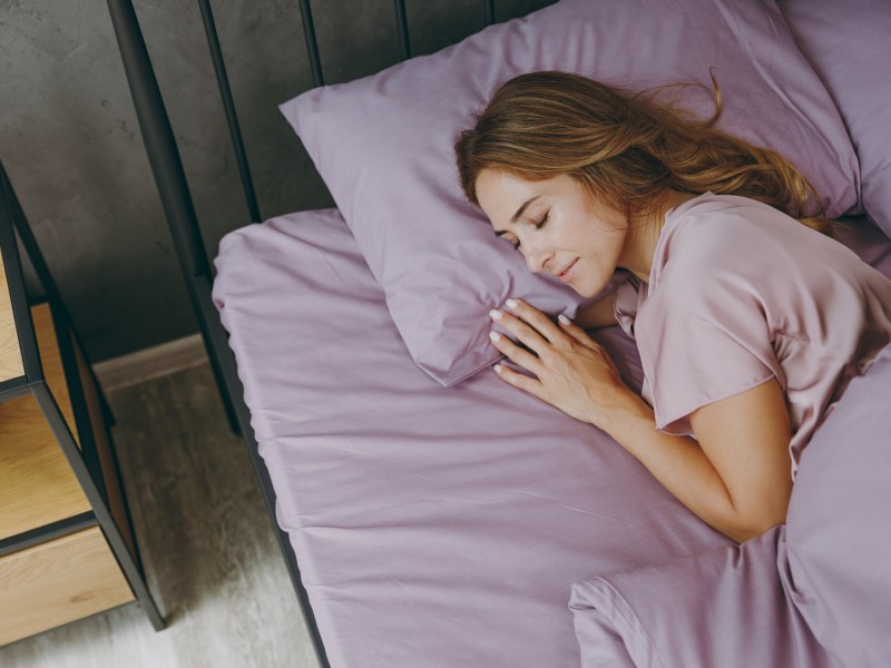 Eine Frau liegt im Bett und schlÃ¤ft.