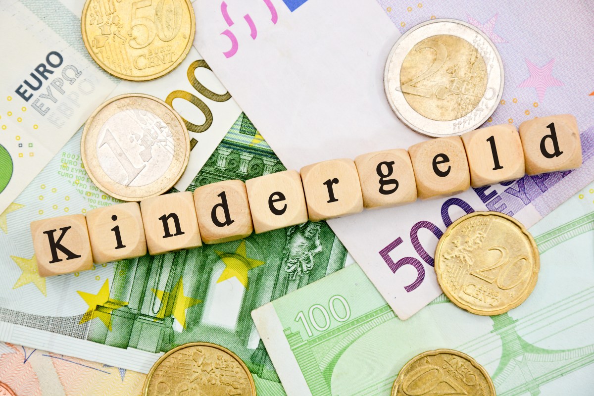 Würfel mit Buchstaben ergeben das Wort "Kindergeld". Sie liegen auf Geldscheinen.