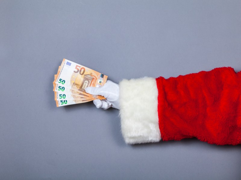 Weihnachtsmann hÃ¤lt 50-Euro-Scheine in Hand