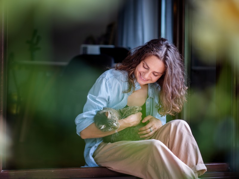 Frau mit Katze auf dem Schoss Katze zugelaufen