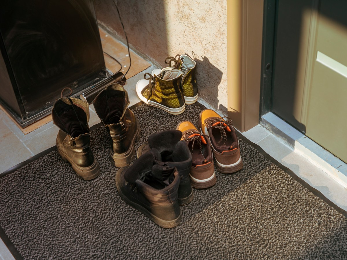 Vier Paar Schuhe stehen vor einer HaustÃ¼r.