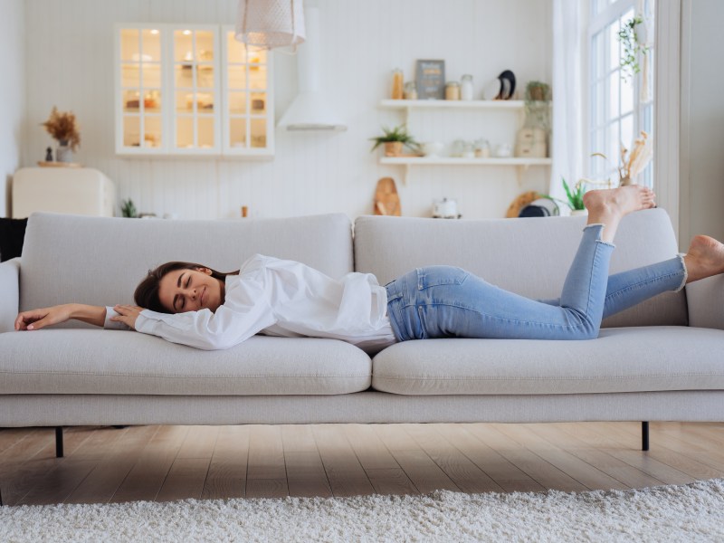 Frau im Wohnzimmer auf dem Sofa