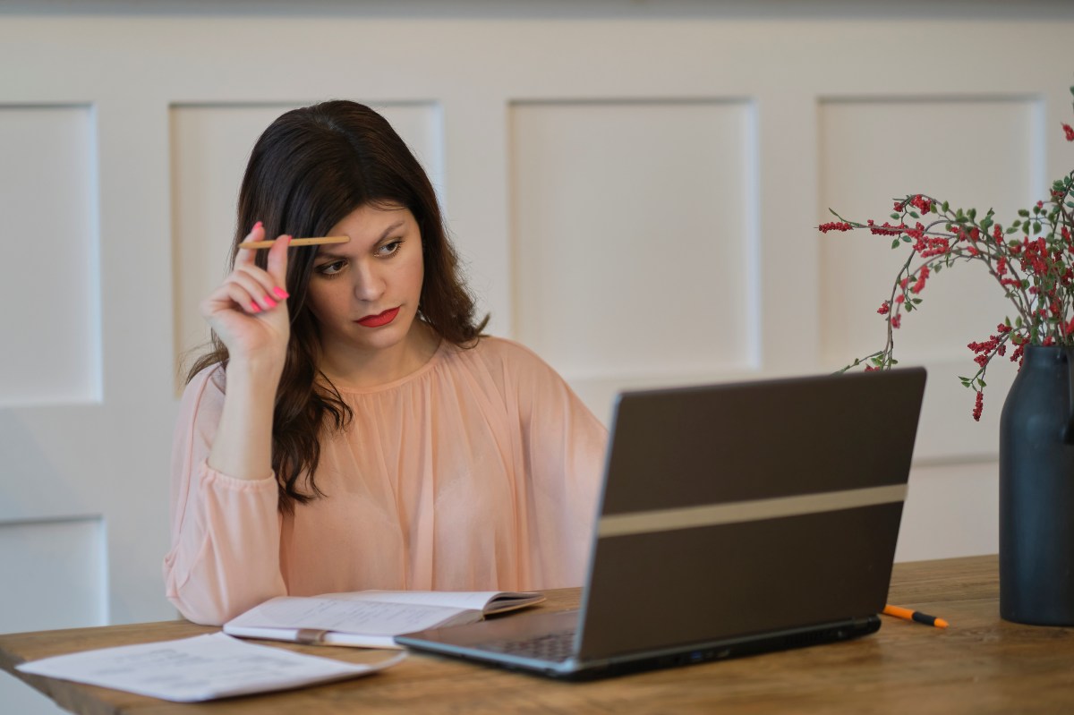 Frau am Laptop: Reisen und Blogging sind ideale Hobbys und coole Side Hustles für das Sternzeichen Schütze