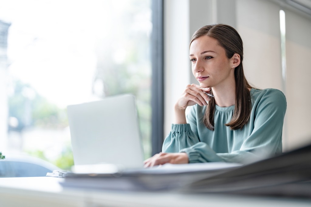 Eine junge Frau sitzt konzentriert am Computer.