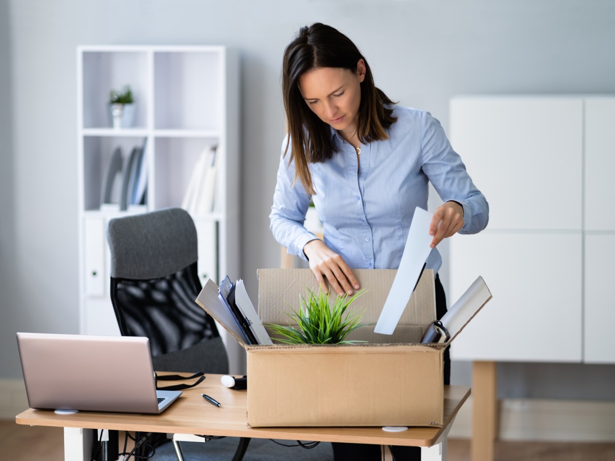 Eine Frau packt im BÃ¼ro ihre Sachen in eine Kiste.