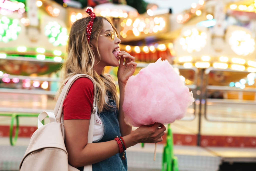 Date auf der Kirmes: Frau isst Zuckerwatte