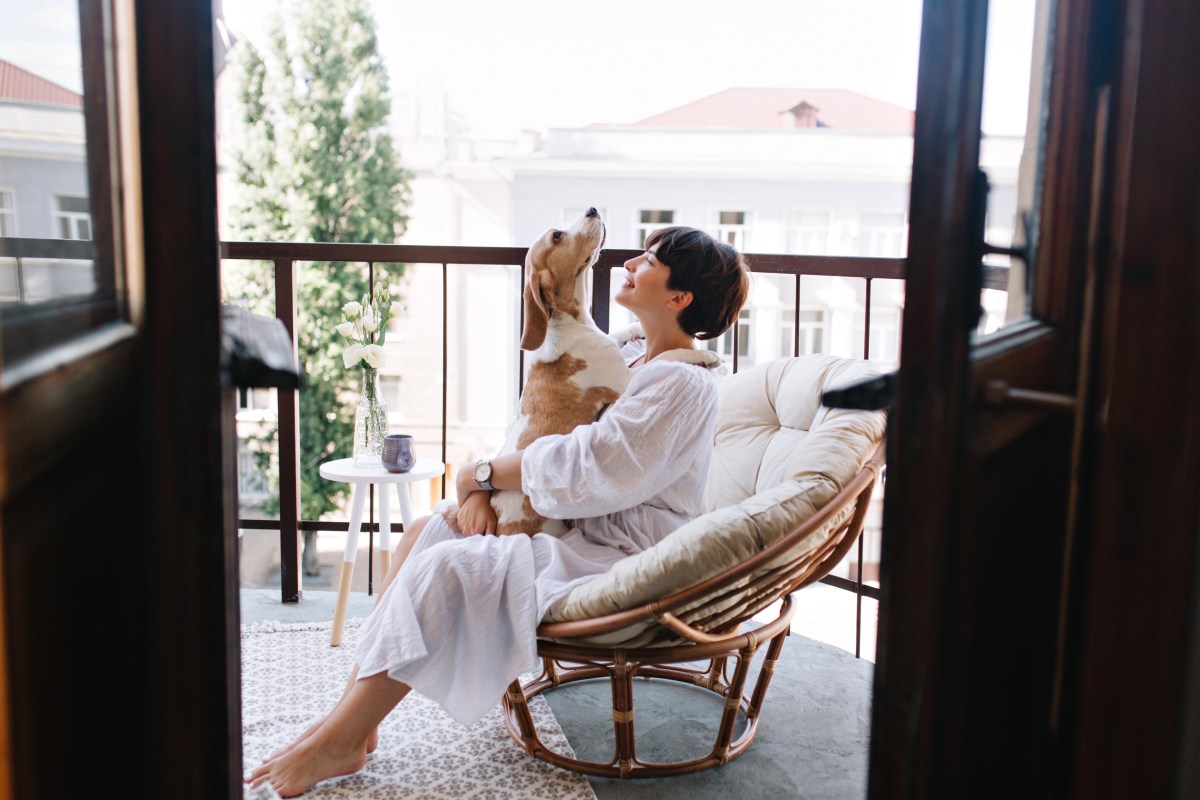 Frau mit Hund auf dem Balkon