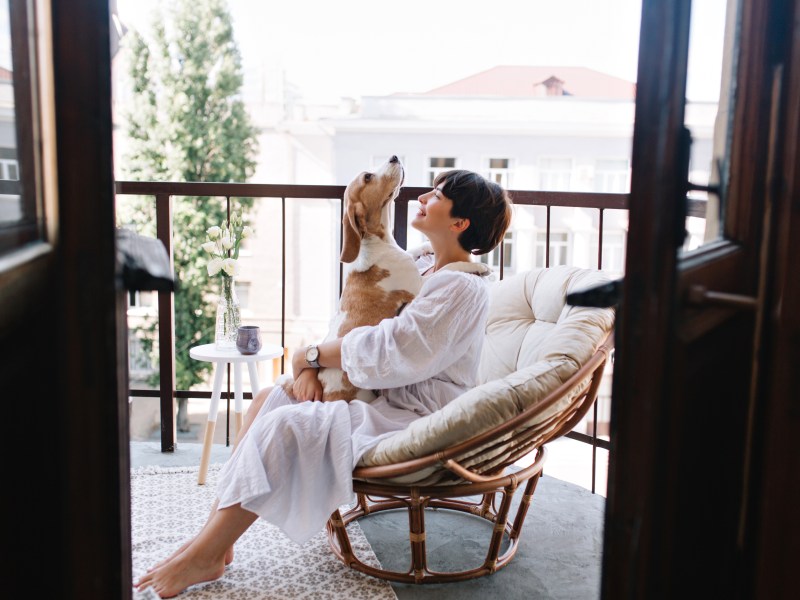 Frau mit Hund auf dem Balkon