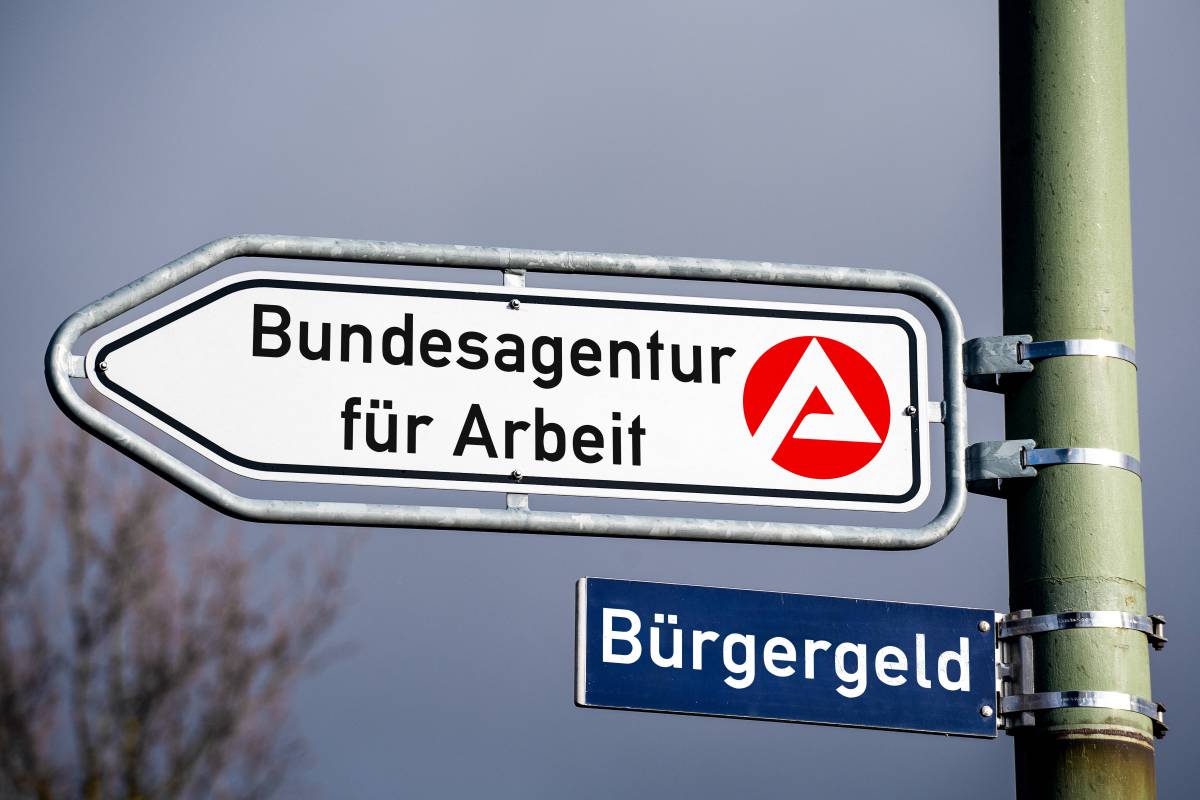 Unter einem Schild der Bundesagentur fÃ¼r Arbeit hÃ¤ngt ein weiteres Schild mit der Aufschrift 